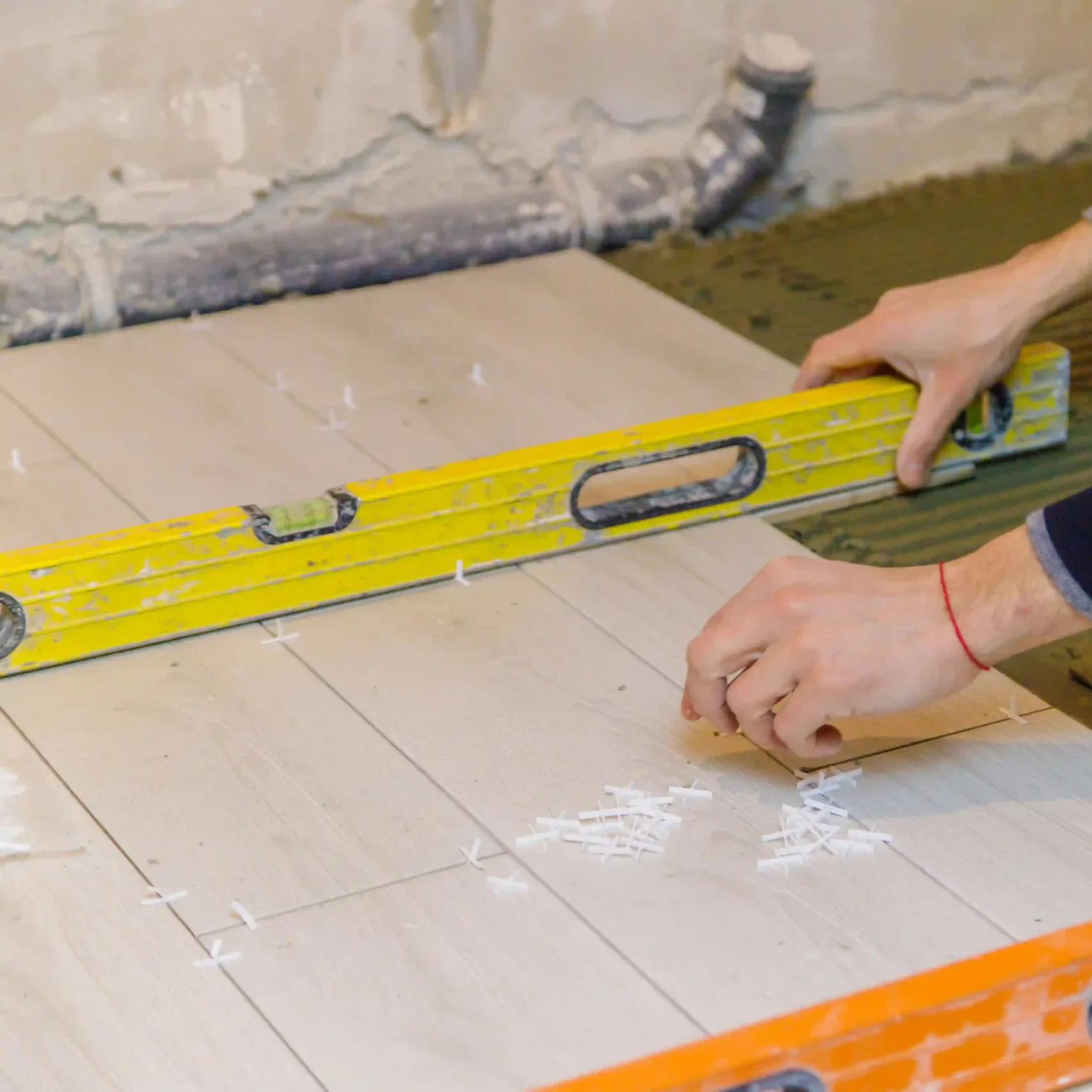 Floor tile installation with leveling tools during a residential tiling project