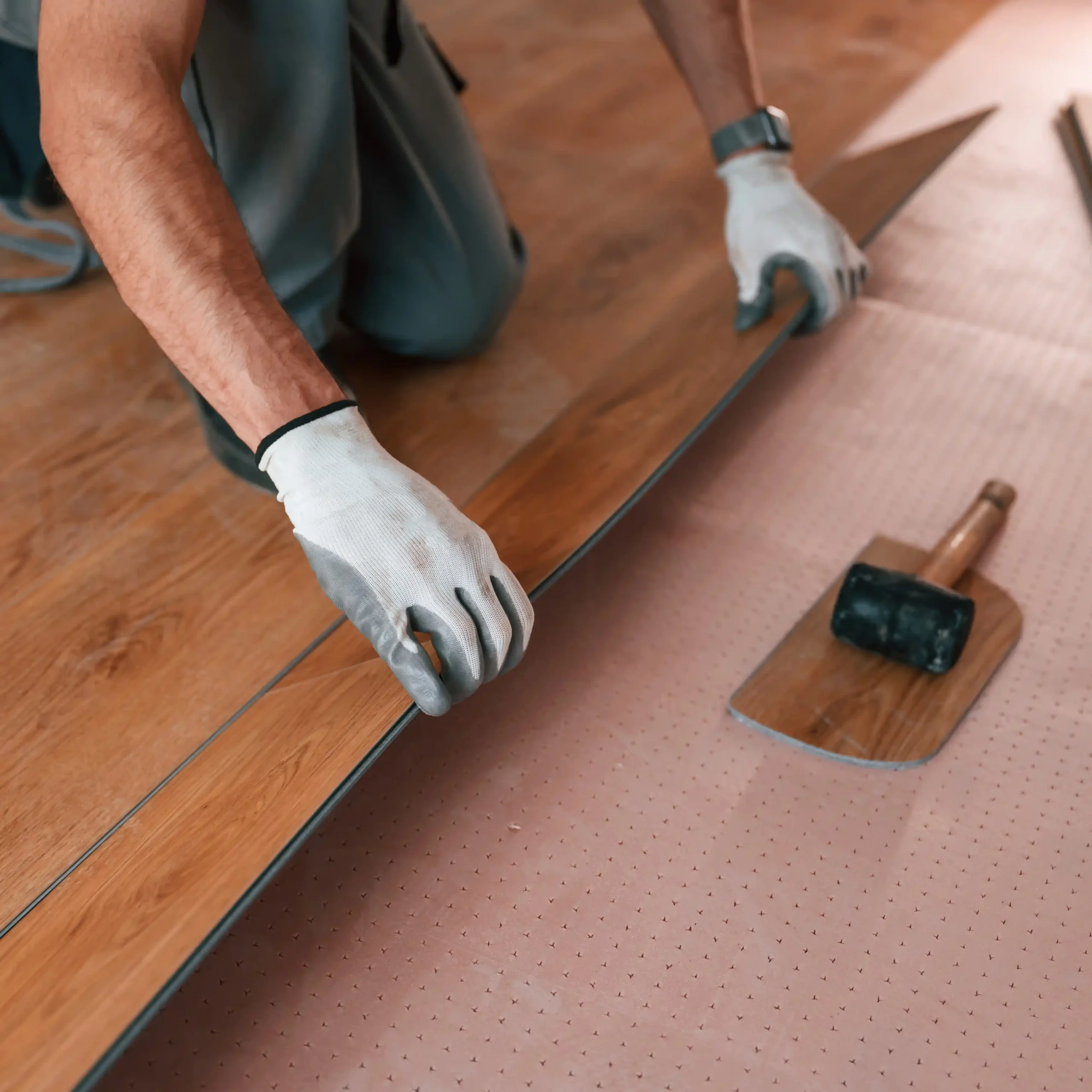 Professional installing laminate flooring with precision tools